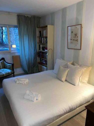 een slaapkamer met een groot wit bed en 2 handdoeken bij Élégant appartement quartierde la Bastille in Parijs