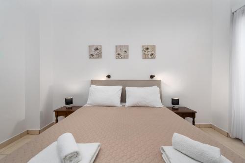 a bedroom with a large bed with two white pillows at Plethora Homes in Kamari