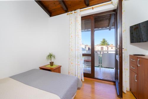 a bedroom with a bed and a sliding glass door at Apartment Pinjola in Poreč