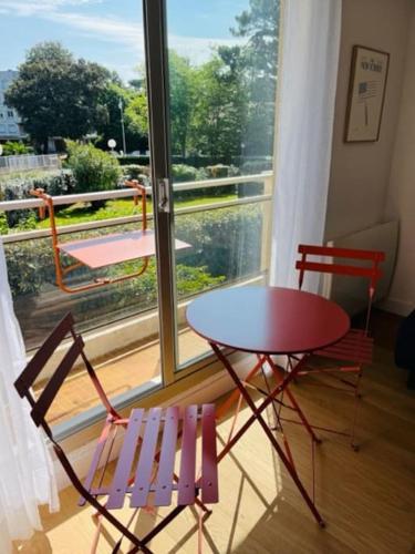 une table et deux chaises devant une fenêtre dans l'établissement Studio idéalement situé, à Arcachon