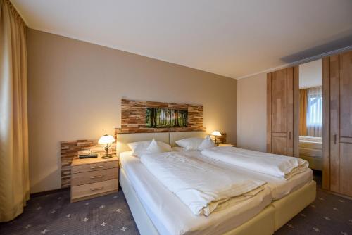 a bedroom with a large white bed and a window at Landhaus Preißinger in Warmensteinach