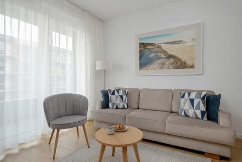 a living room with a couch and a chair at Baltic Marina Residence Studios with Balcony & Pet Friendly by Renters in Kołobrzeg