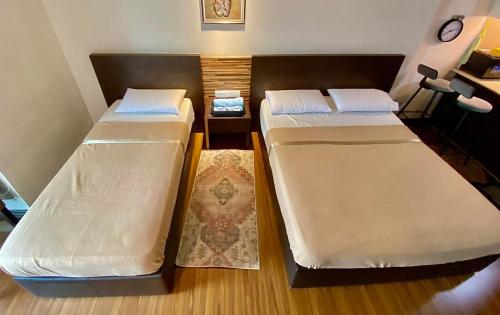 twee bedden in een kleine kamer met bij Ain Studio Apartment in Kota Bharu