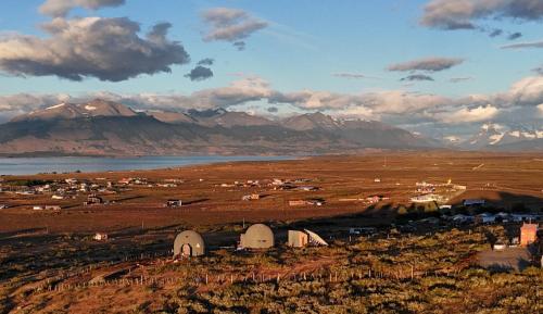 a group of tents in a field with mountains at Dome with Stunning Glacier & Mountain Views in Puerto Natales