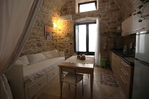 ジョヴィナッツォにあるRubini's Houseのベッドとテーブルが備わる小さな客室です。