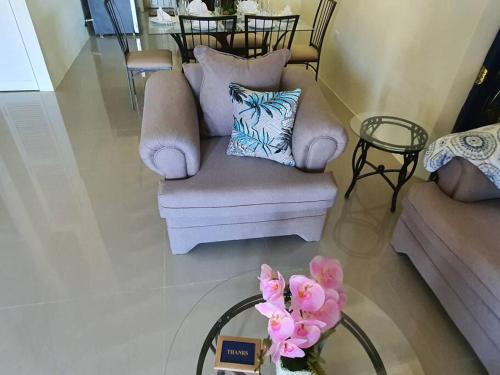 a living room with a couch and a table with flowers at Gil- Manor in Falmouth