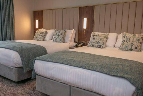 a hotel room with two beds in a room at voco The Clifton Folkestone by IHG in Folkestone