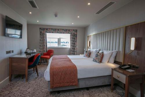 Habitación de hotel con cama grande y escritorio. en Best Western Clifton Hotel, en Folkestone