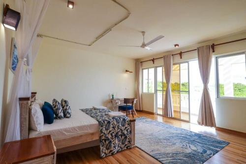 een slaapkamer met een bed en een groot raam bij Zuhri Villas Diani in Diani Beach