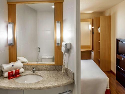 a bathroom with a sink and a mirror at ibis Belo Horizonte Afonso Pena in Belo Horizonte