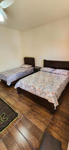 a bedroom with two beds and a table in it at Pousada Brilhante Itirapina in Itirapina