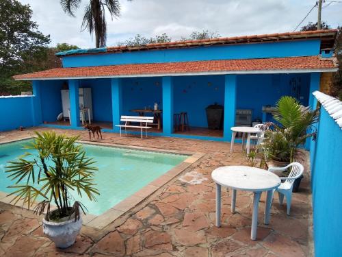a villa with a swimming pool in front of a house at Pousada Brilhante Itirapina in Itirapina