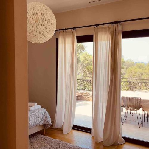 1 dormitorio con ventana y vistas a un balcón en Villa au sommet des collines en toute intimité, en Vidauban
