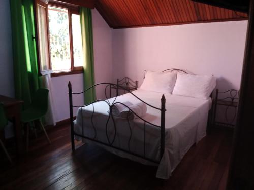 sypialnia z łóżkiem z białą pościelą i oknem w obiekcie Auberge Nofiko w mieście Talata-maty