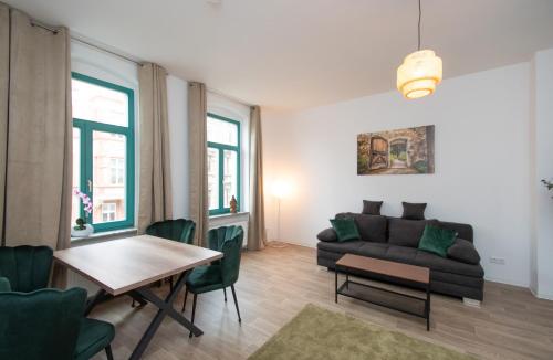 a living room with a couch and a table at Room&Go: Zentral - Balkon - Arbeitsplatz in Halle an der Saale