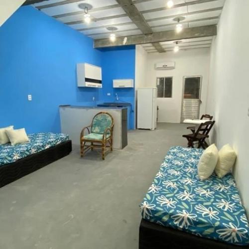 Zimmer mit 2 Betten und blauer Wand in der Unterkunft Cantinho da Enseadinha in Paulista
