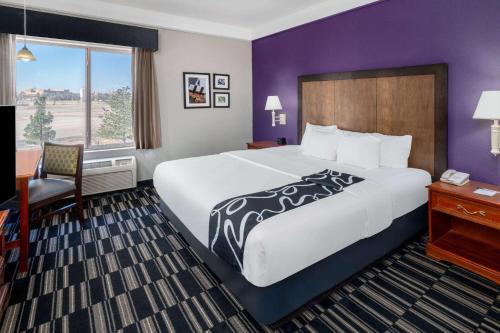 una camera d'albergo con un grande letto e una scrivania di La Quinta by Wyndham Roswell a Roswell