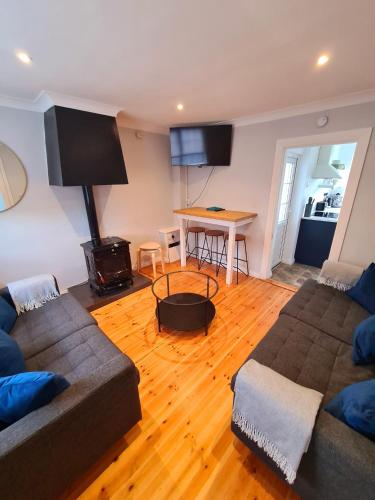 a living room with two couches and a wooden floor at Stylish 3 Bedroom Galway House in Galway