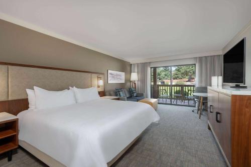 Cette chambre comprend un grand lit blanc et une télévision. dans l'établissement Cheyenne Mountain Resort, a Dolce by Wyndham, à Colorado Springs