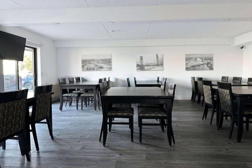 a dining room with tables and chairs and pictures on the wall at Travelodge by Wyndham Welland in Welland