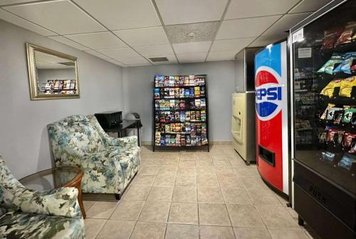 a room with a soda machine and chairs in a store at Travelodge by Wyndham Welland in Welland