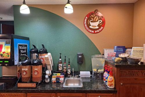 a counter in a coffee shop with bottles on it at AmericInn by Wyndham Vidalia in Vidalia
