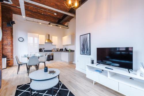 Una sala de estar con un televisor grande y una mesa. en Meadow Mill by Staycay, en Stockport