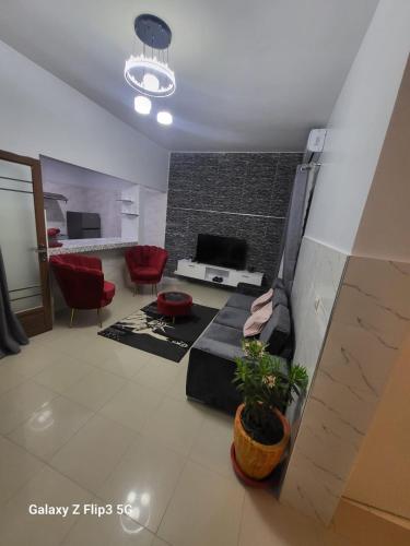 a living room with a couch and red chairs at Paradis Appartement in Ngor