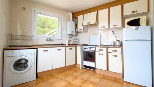 a kitchen with white cabinets and a washer and dryer at Majordoms - Apartment Cau del Llop, Llança in Llança