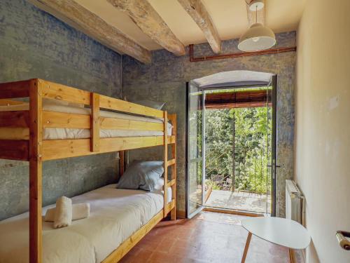 1 Schlafzimmer mit 2 Etagenbetten und einer Glasschiebetür in der Unterkunft Mas Simon, Centenys in Esponellá