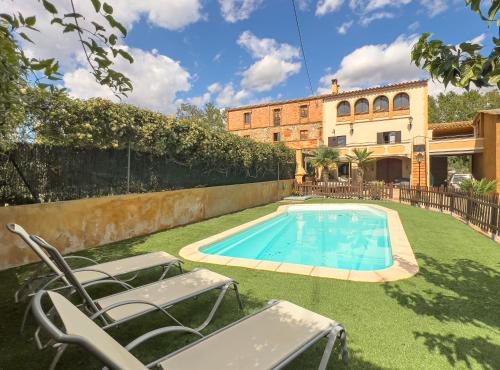 un patio trasero con piscina y una casa en Private country house with pool and barbecue, en Girona