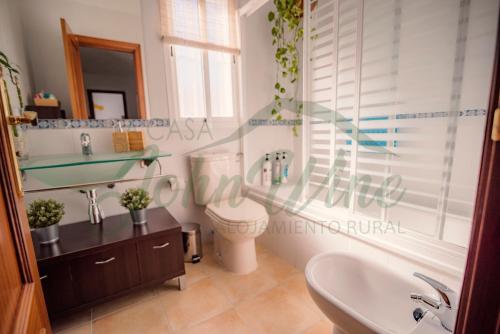 a bathroom with a sink and a toilet and a tub at La casa de John Wine , Bornos (Spain) in Bornos