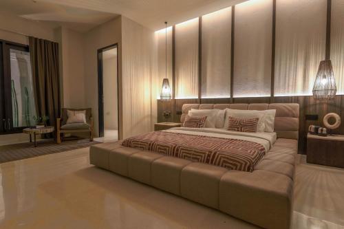 a bedroom with a large bed and a couch at Ahimsa Beach in Jimbaran