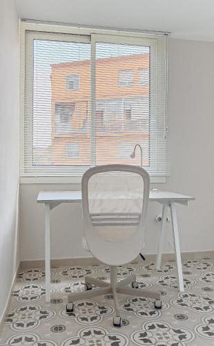 a white desk and a chair in front of a window at Majordoms - Ca les Cosines 47 in Banyoles