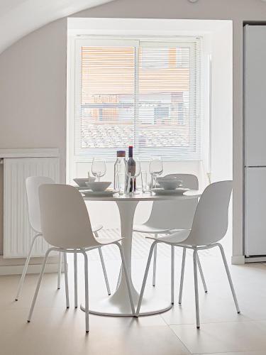 a white dining room with a white table and chairs at Majordoms - Ca les Cosines 47 in Banyoles