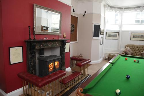 a living room with a pool table and a fireplace at Thistlebank Townhouse in Whitby