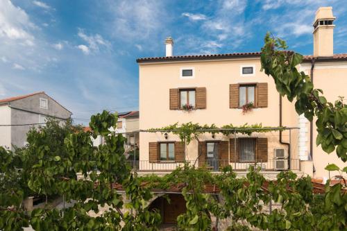a large white building with wooden shutters at Apartments Gabi in Punat