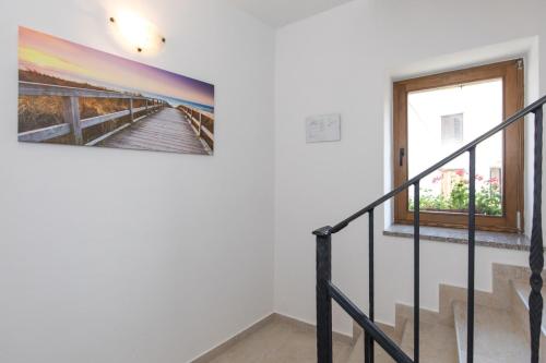 a staircase in a house with a painting on the wall at Apartments Gabi in Punat