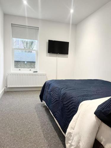 biała sypialnia z łóżkiem i oknem w obiekcie Luxury 3 Bedroom House w mieście Worthing