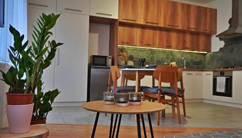 Főtér Apartman في كيسكونهالاس: مطبخ مع طاولة وكراسي في غرفة