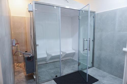 a bathroom with a glass shower with a toilet at The Healing Hills Naturopathy and Wellness Center in Coimbatore