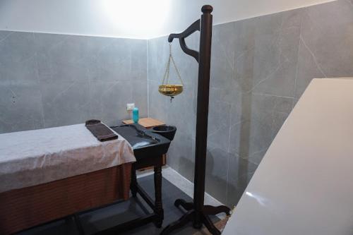 a room with a bed and a desk with a light at The Healing Hills Naturopathy and Wellness Center in Coimbatore
