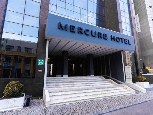 a meerle hotel building with stairs in front of it at Mercure Baku City in Baku