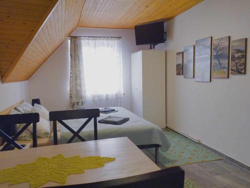 um quarto com uma cama, uma mesa e uma janela em Viola Apartmanház em Bogács