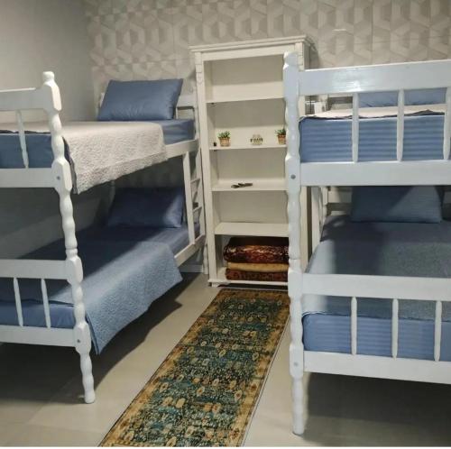 a bedroom with two bunk beds and a rug at Hostel SIL CARDOSO in Blumenau