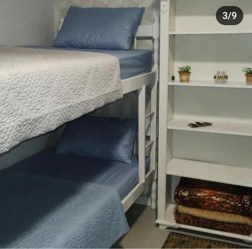 a bunk bed with blue pillows in a bedroom at Hostel SIL CARDOSO in Blumenau