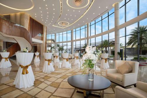 een lobby met witte bloemen en tafels en stoelen bij Wyndham Grand Phu Quoc in Phu Quoc