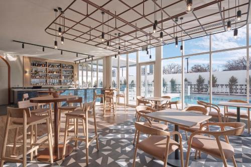 un restaurant avec des tables et des chaises ainsi qu'une piscine dans l'établissement Hotel Alba Adelaide, à Adélaïde