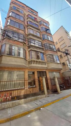 Elegante Apartamento en La Paz في لاباز: مبنى طويل امامه سياج