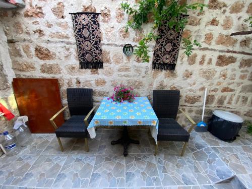 a table and chairs with flowers on a stone wall at PORT APART in Antalya